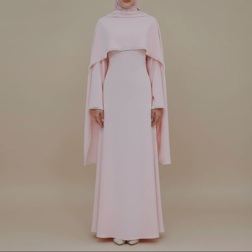 Pink dress on a mannequin with a vase of dried plants in a minimalistic setting