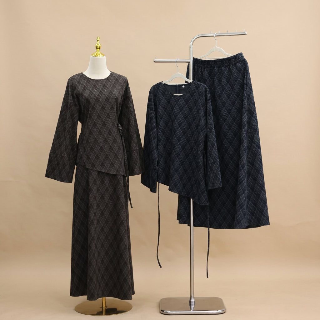 A dark brown and black argyle patterned two-piece set displayed on a mannequin, alongside a matching asymmetrical long-sleeve top and skirt set on a clothing rack against a white paneled wall.