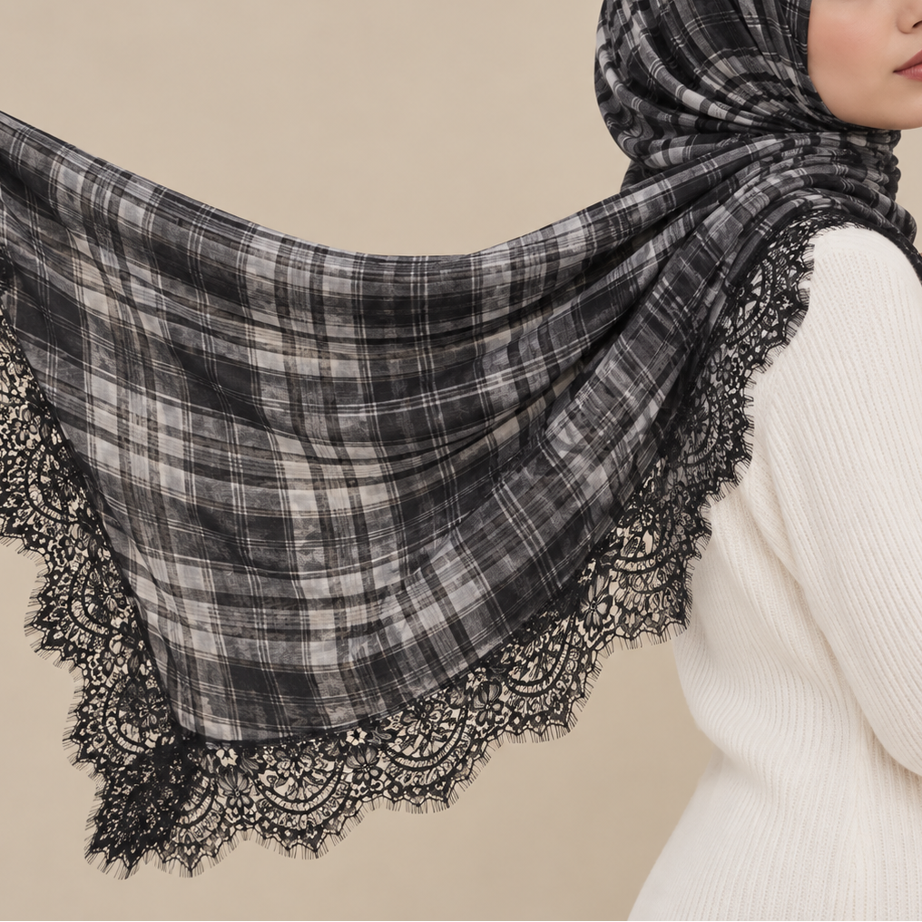 A woman wearing a black and gray plaid shawl with a black lace border, draped over her shoulders and head, against a solid beige background.
