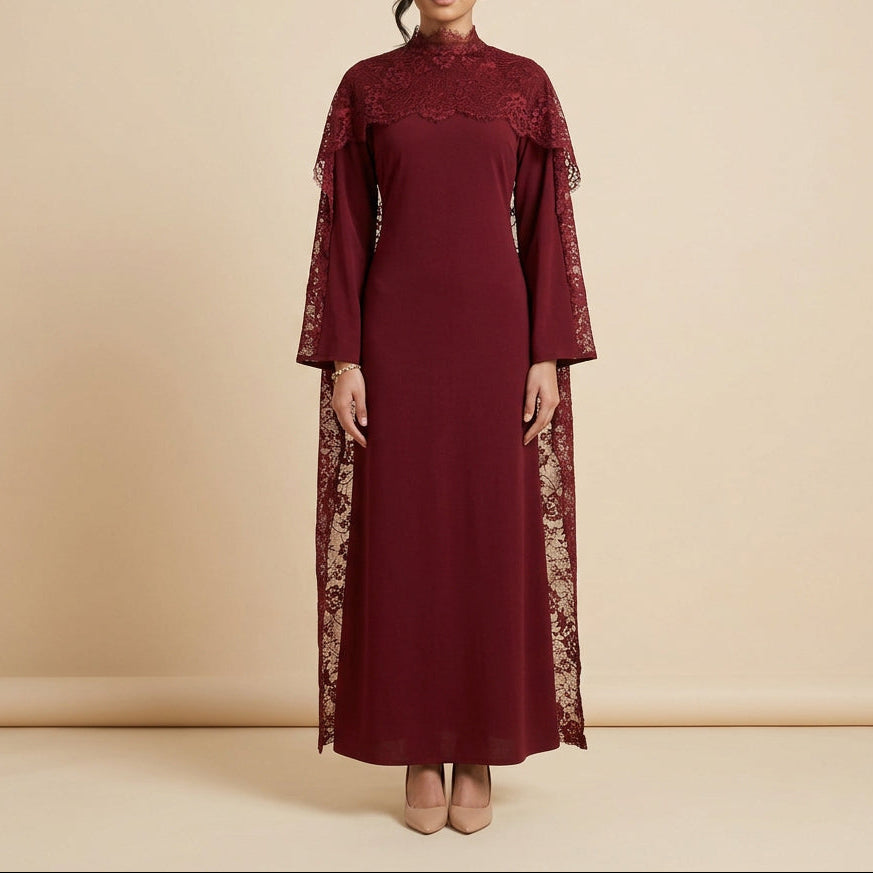 A long-sleeved dark red dress displayed on a mannequin against a white paneled wall, featuring lace detailing on the shoulders, sleeves, and lower skirt.
