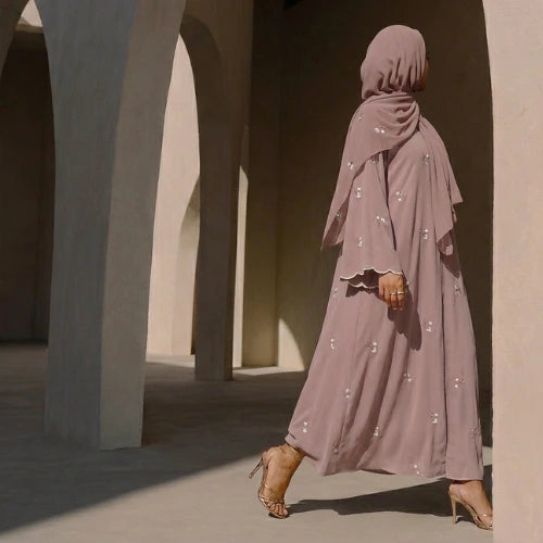 Faceless woman walking through arches wearing a textured mauve abaya set and matching hijab by Try Modest, showcasing elegant modest wear.
